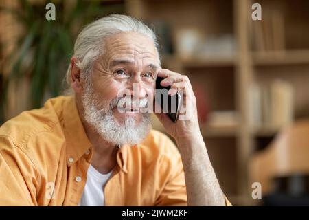 Emotional old man having phone conversation, looking at copy space Stock Photo