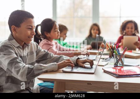 African American Schoolboy Using Laptop Computer Learning Online At School Stock Photo