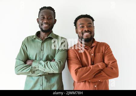 Two Smiling Black Men Posing Standing Crossing Hands, White Background Stock Photo