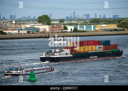 Shipping traffic on the Maas, height Hoek van Holland, inland cargo ship, container freighter, skyline of Rotterdam, Stock Photo