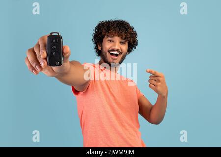 Cheerful driver young bearded Indian man holding new car key Stock Photo