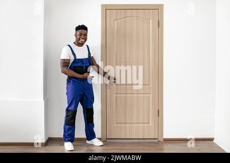 Black Male Worker Pointing Finger At New Entry Door Indoors Stock Photo
