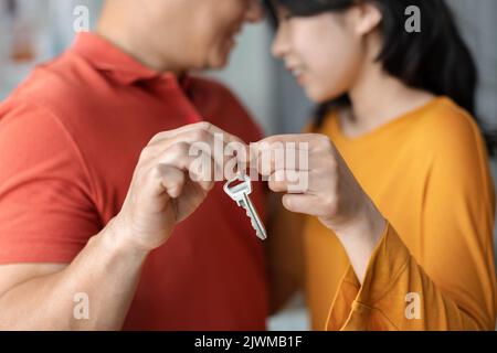 Cropped of chinese husband and wife holding key from house Stock Photo