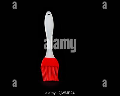 red and white  silicon pastry brush on a black background Stock Photo