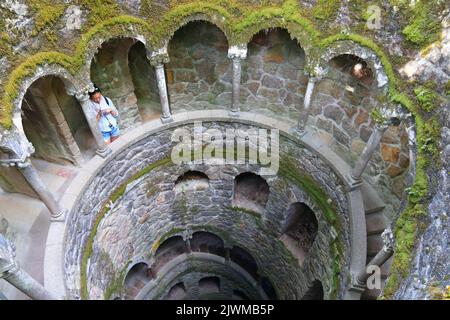 SINTRA, PORTUGAL - MAY 21, 2018: Tourists visit Initiation well of Quinta da Regaleira park in Sintra. Portugal had 12.7 million foreign visitors in 2 Stock Photo