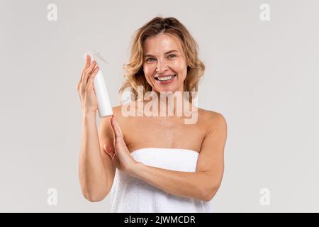 Hairstyle Cosmetic. Beautiful Middle Aged Woman Holding Bottle With Hair Spray Stock Photo