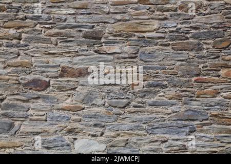 Retro rustic stone wall texture. Natural stone wall background. Stock Photo