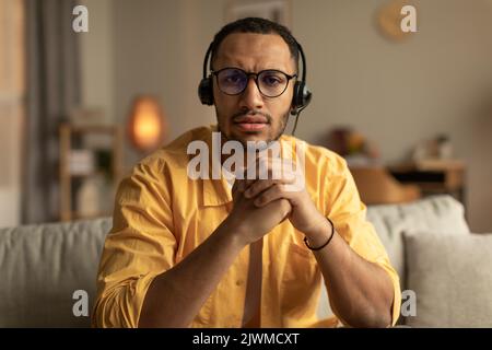 Focused young black man having online meeting, solving problem, communicating with partners on web from home Stock Photo