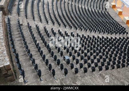 Audience seats - empty event venue in France. Grey plastic chairs. Stock Photo