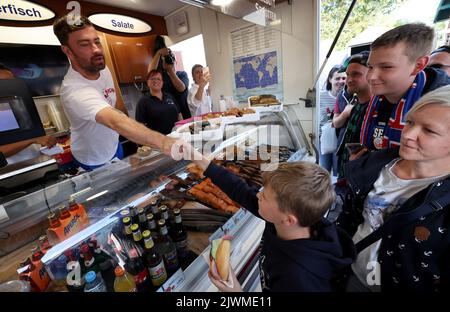 06 September 2022, Mecklenburg-Western Pomerania, Warnemünde: Rapper Marteria gives away about 500 fish rolls to his fans on the Warnemünde pier. With the action Marteria wants to make advertising for his stadium concert on 02.09.2023 in Rostock, because in addition to the rolls there were also codes for an advance sale of tickets. Photo: Bernd Wüstneck/dpa Stock Photo