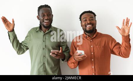 Two Black Guy Using Smartphones Waving Hands, White Background, Panorama Stock Photo