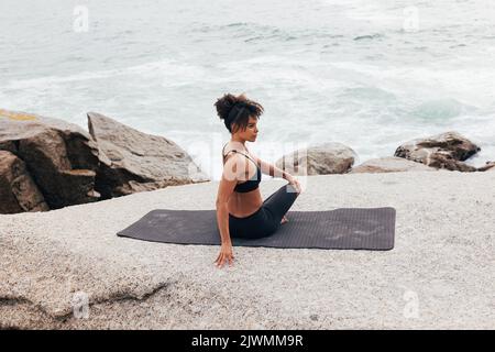 Woman doing side turn on mat warming up her body before yoga training Stock Photo