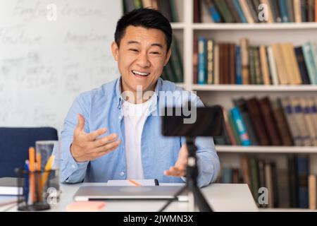 Asian Tutor Having Online Class Teaching Distantly Using Smartphone Indoor Stock Photo