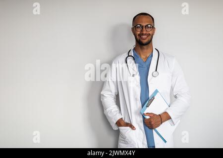 Portrait of cheerful arab doctor holding medical chart Stock Photo