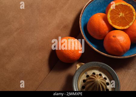 Still life with oranges on blue plate over wooden board Stock Photo