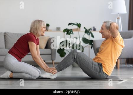 Sporty mature couple having workout at home, copy space Stock Photo