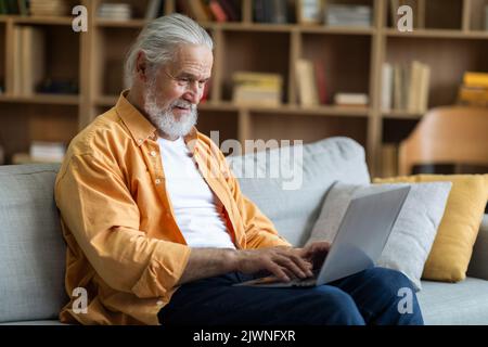 Side view of elderly man using computer at home Stock Photo