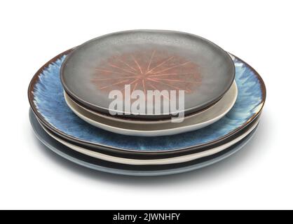 Stack of different rough trendy handmade ceramic plate isolated on white Stock Photo