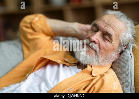 Closeup of sleeping senior man, resting on sofa at home Stock Photo
