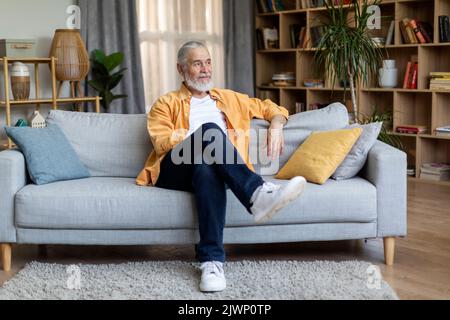 Relaxed elderly man chilling on couch at home Stock Photo