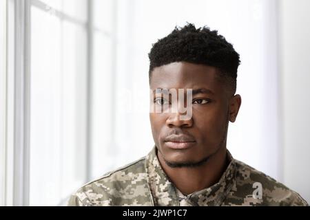 Serious african american man soldier looking through the window Stock Photo