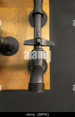 details of a metal faucet on a wooden base, texture and design element, pipe for water, object Stock Photo