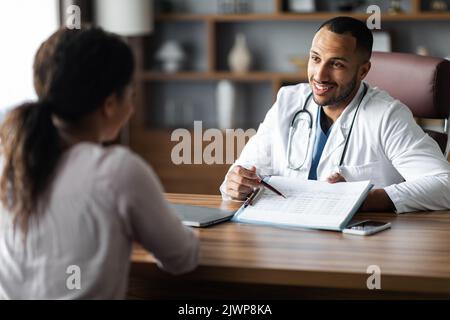Friendly african american doctor having conversation with female patient Stock Photo