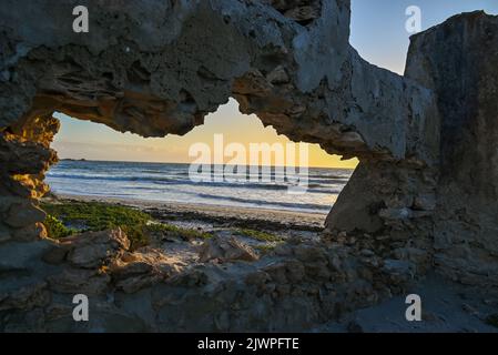 Hole in a wall on beach Stock Photo