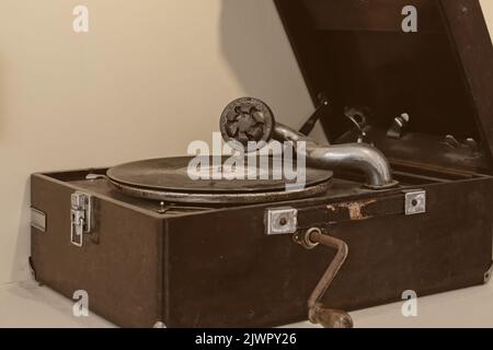 Portable vintage wind-up acoustic gramophone Leophone.Selective focus to needle and old disk of aged retro phonograph. Stock Photo