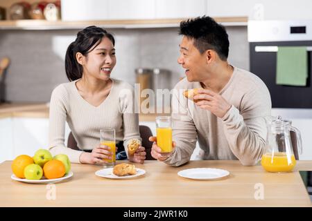 Cheerful korean lovers having snack together at home Stock Photo