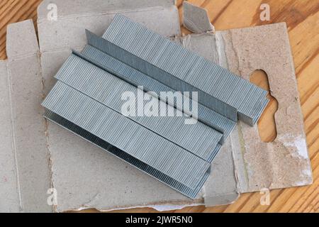 Metal staples for staple machine on woodenn background close up Stock Photo
