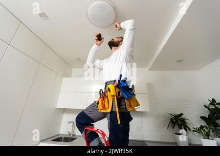 electrician installing led light bulbs in ceiling lamp Stock Photo