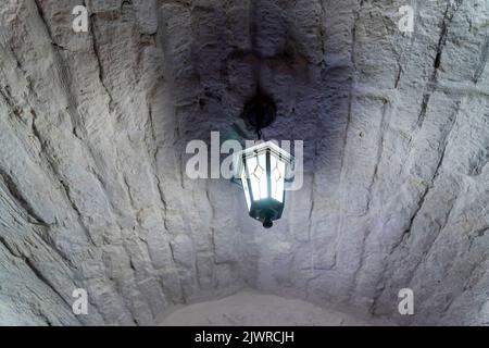 Vintage lantern hanging under the brick arch in the restaurant. Decor Stock Photo