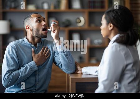 Black man suffering from asthma attack, using nebuliser Stock Photo