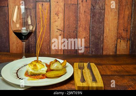 Cod loin with au gratin apple alioli sauce on tomato confit. Stock Photo