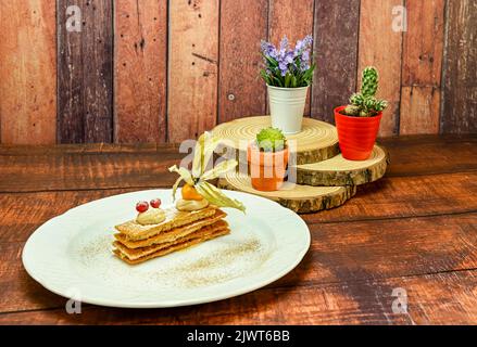 Crunchy inverted puff pastry mille-feuille with caramel and toffee mousse. Stock Photo