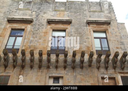 Casarano, Italy. Exterior view of Palazzo D'Aquino. Long row of figured corbels for supporting a balcony that was never built. Stock Photo