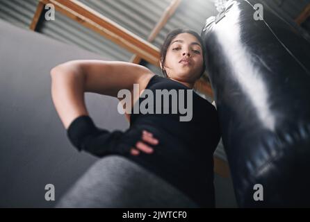 The view from the top. Studio shot of a female kickboxer against a gray background. Stock Photo