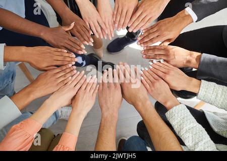 Multiethnic team of people joining hands showing concepts of community and teamwork Stock Photo
