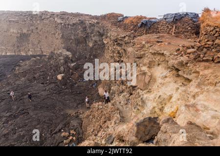 AFAR, ETHIOPIA - MARCH 26, 2019: Tourists climbing out of the Erta Ale volcano crater in Afar depression, Ethiopia Stock Photo