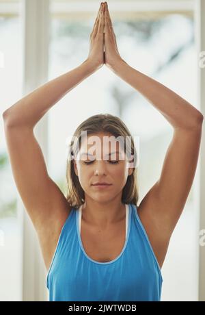 Shes got this yoga thing down. a young woman practicing yoga at home. Stock Photo