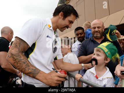 Australian cricket team fast bowler Mitchell Johnson poses for a photograph  with young fan Kai Scott, 8, after signing an autograph, at a public event  to celebrate the Australian Test cricket team