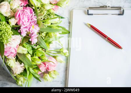 Happy Teachers Day, boss day concept card and bouquet.Bouquet of beautiful fresh flowers with clipboard and pen on white background. Floral mock up Stock Photo