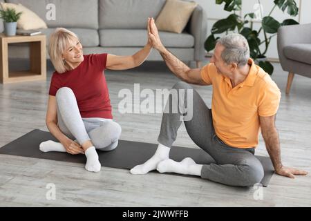 Happy mature man and woman having workout, giving high five Stock Photo