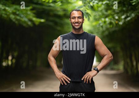 Handsome athletic guy jogging in public park Stock Photo