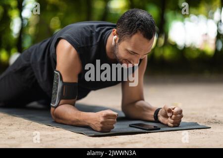 Motivated black sportsman planking at public park Stock Photo