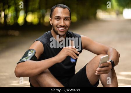 Hungry african american sportsman eating protein bar Stock Photo