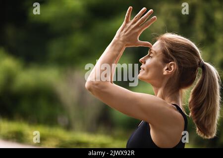 Young woman practicing meditation at public park Stock Photo