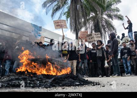 Kendari, Indonesia. 06th Sep, 2022. Protesters chant slogans while holding placards behind a burning tire during a demonstration. Credit: SOPA Images Limited/Alamy Live News Stock Photo