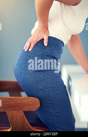 Businesswoman with lower back pain, sitting on office chair Stock Photo ...
